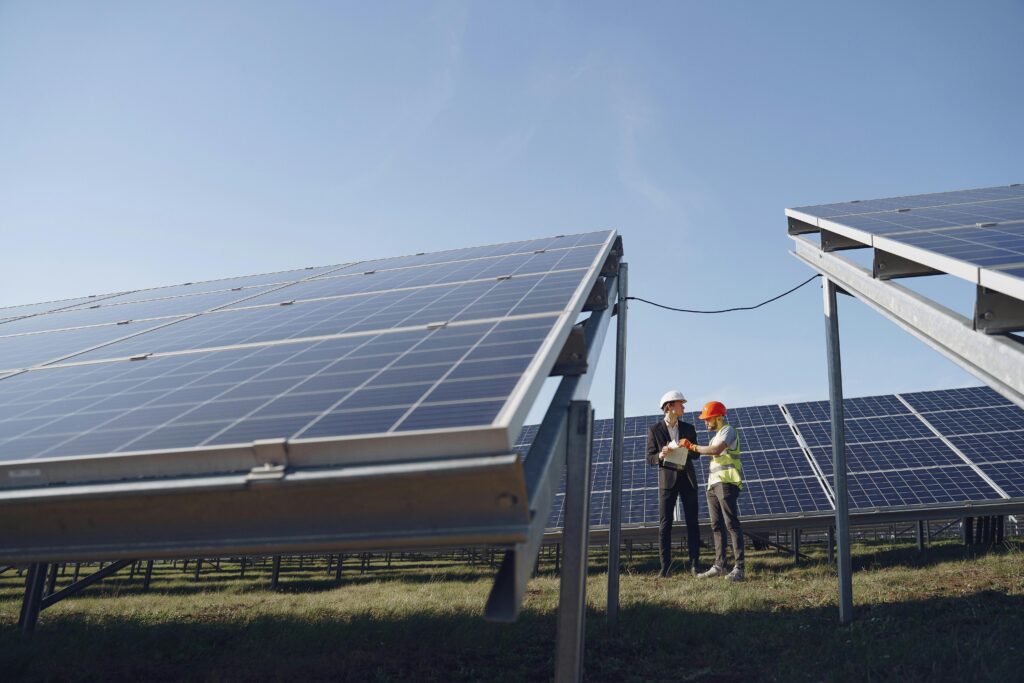Series vs. Parallel Solar Wiring: How to Not Cook Your Charge Controller Supervisor in hardhat and formal wear discussing project with workman in uniform while standing with papers near modern solar panels under blue sky