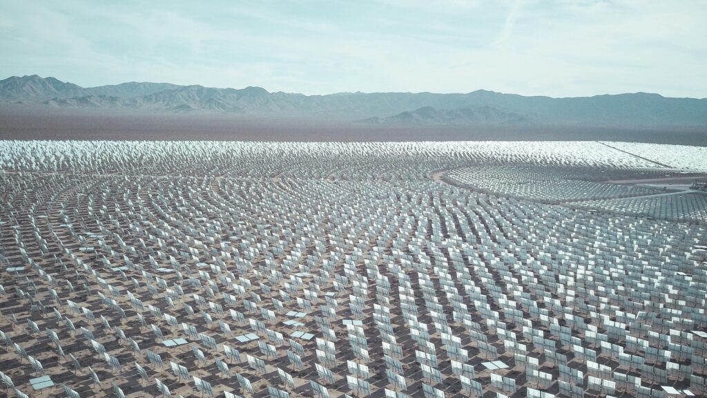 Aerial view of a vast solar farm in a desert setting, capturing renewable energy technology.